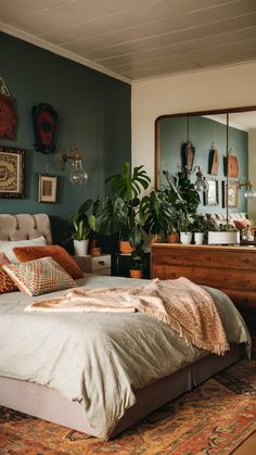 a bed sitting in a bedroom next to a dresser with plants on top of it