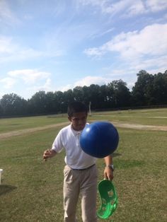 a young boy holding a blue and green frisbee