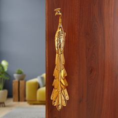 a golden door handle on a wooden door in a room with grey walls and furniture