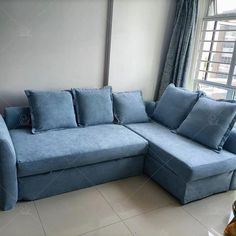 a blue couch sitting in front of a window