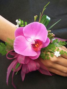 a woman's hand holding a pink flower bouquet