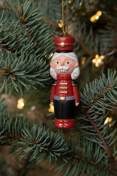 a nutcracker ornament hanging from a christmas tree