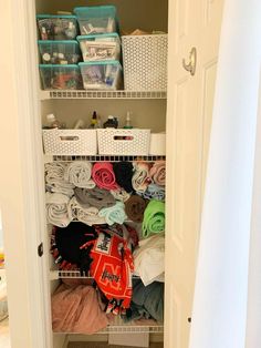 the closet is full of clothes and other items in baskets, including blankets, towels, and shoes