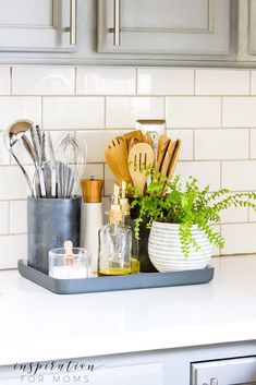 kitchen utensils are arranged in a tray on the counter