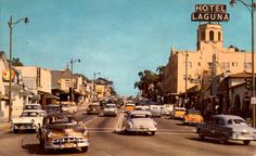 an old photo of cars driving down the street in front of hotel laguna