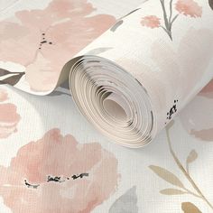 a roll of pink and grey floral wallpaper on top of a white tablecloth