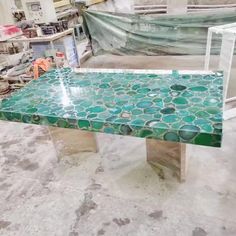 a table made out of green and white tiles