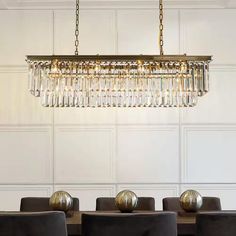 a chandelier hanging from the ceiling over a dining room table with black chairs