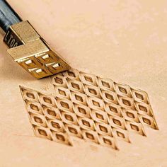 a close up of a golden object on a table with a pen in the middle