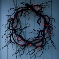 a wreath made out of branches with red lights