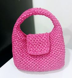 a pink purse sitting on top of a white table