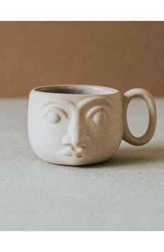 a ceramic cup with a face on it