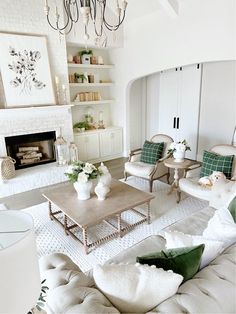 a living room filled with furniture and a fire place under a chandelier in front of a fireplace