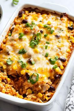 an enchilada casserole with corn and black beans in a white dish