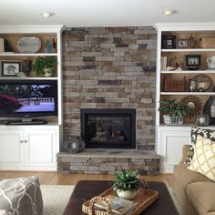 a living room filled with furniture and a fire place in front of a tv mounted on a wall