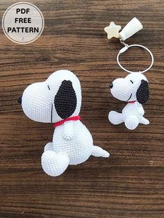 a white and black dog keychain sitting on top of a wooden table next to a bottle opener