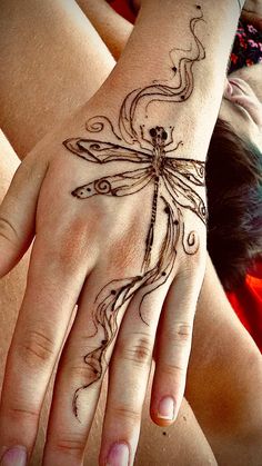 a woman's hand with a dragon tattoo on it and an intricate design in the middle