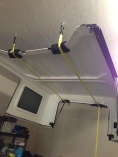 two wires are attached to the ceiling above a microwave