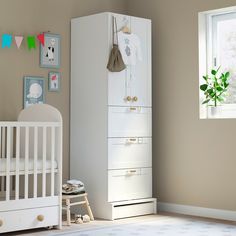 a baby's room with a white crib and dresser