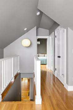 an empty room with hard wood floors and white railings on the second floor is shown