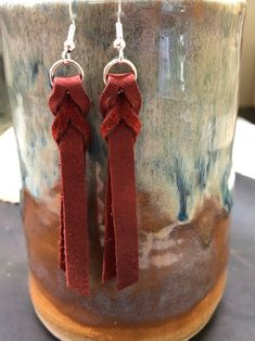 two red tassels are hanging from a cup