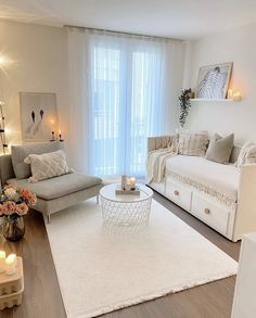 a living room filled with white furniture and lots of candles on top of the coffee table