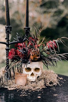 there is a skull with flowers in it on the table