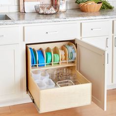 an open drawer in a kitchen filled with dishes