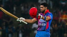 a man holding a bat and ball in his hands