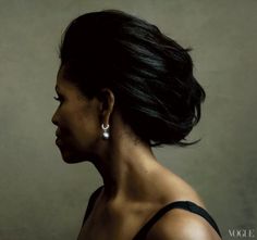 a woman with black hair and earrings looking off to the side