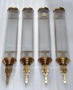 four brass and glass sconces on a white background