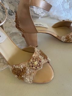 a pair of women's wedding shoes with gold embellishments