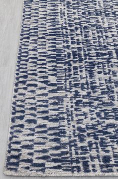 a blue and white rug on the floor with an area rug in front of it