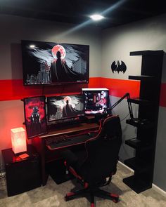 a computer desk with two monitors and a batman poster on the wall above it in a home office