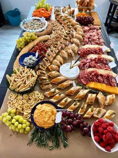 a long table filled with lots of different types of foods and cheeses on top of it