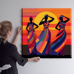 a woman standing in front of a painting with two women on it's sides