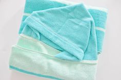 three towels folded on top of each other in blue and green colors with white stripes