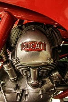 the ducati logo is displayed on an old red motorcycle's front end engine