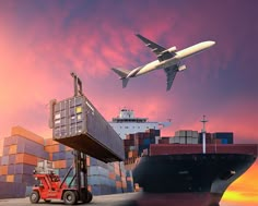 an airplane is flying over shipping containers and a forklift with a cargo ship in the background