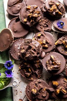 chocolate covered cookies are sitting on a tray with flowers and spoons next to it