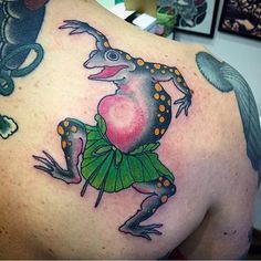 a frog tattoo on the back of a man's shoulder