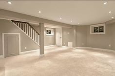 an empty living room with carpet and stairs