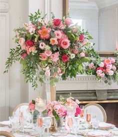 an elegant table setting with pink flowers and greenery