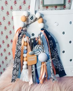 an assortment of scarves hanging from a white purse on top of a fur rug