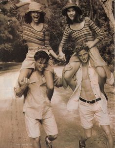 three people walking down a dirt road with one holding the other's hand and smiling