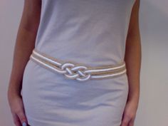 a woman is wearing a dress with a knot on it