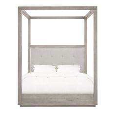 a bed that has a white blanket and pillows on it, with a gray frame