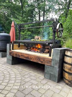 an outdoor fire pit made out of wood and metal with a large wheel on top