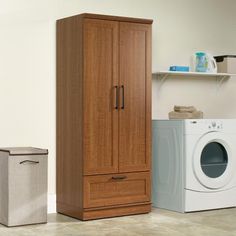 a washer, dryer and cabinet in a room with tile flooring on the floor