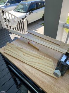 a piece of wood being cut with a pair of scissors on top of the table